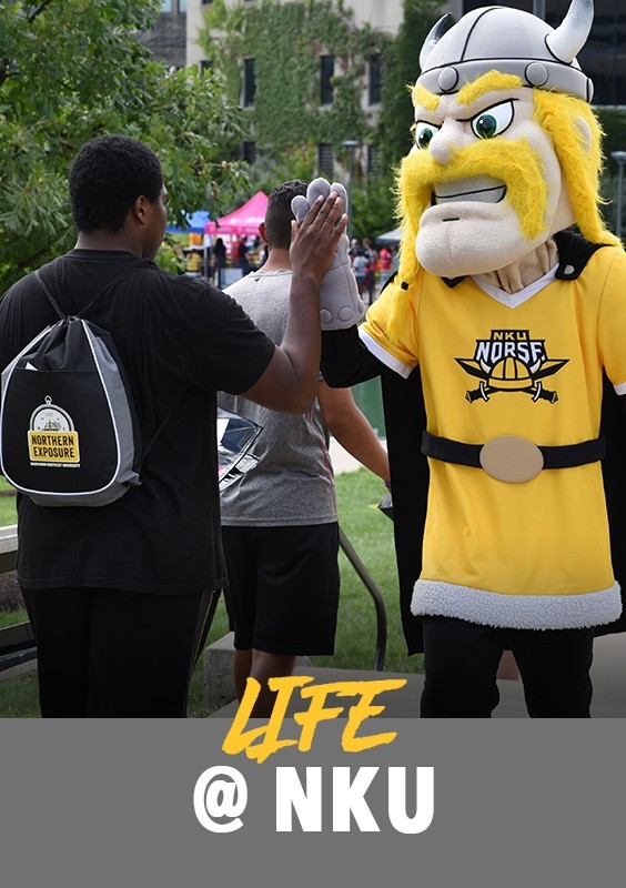 Life at ͷԭ: Student at an event giving Victor E. Viking a high-five